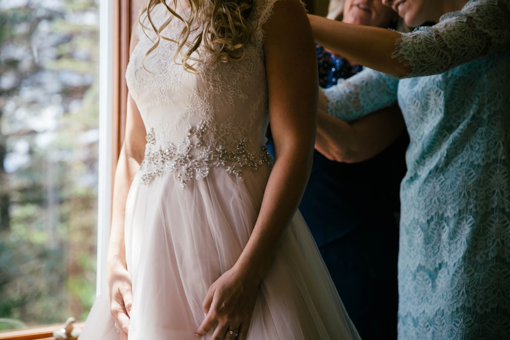 mulher vestindo vestido de noiva branco sem mangas perto da árvore