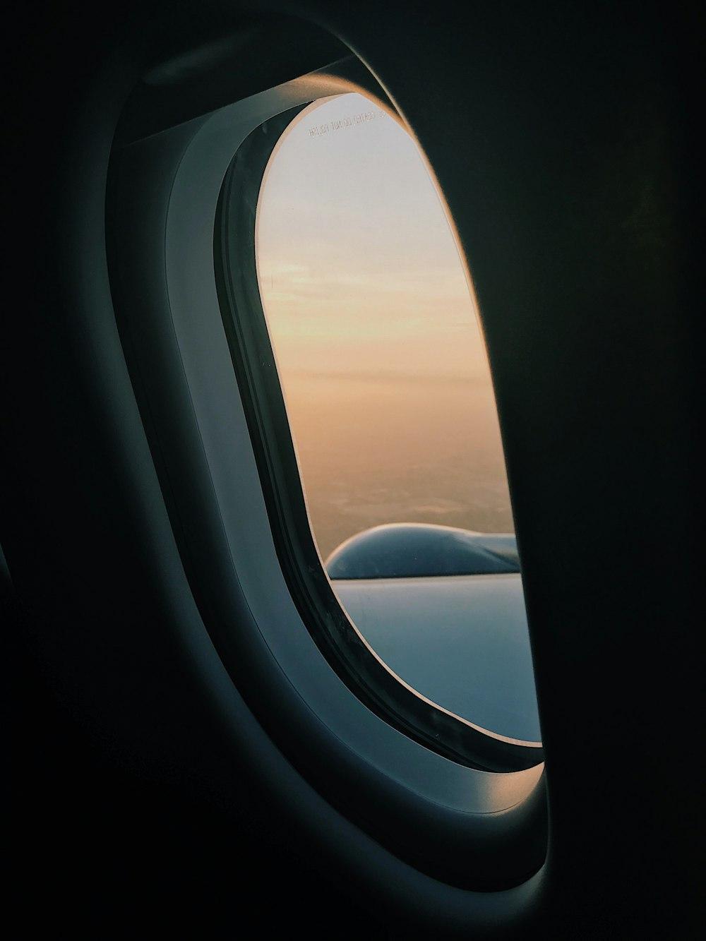 Persona dentro del avión a gran altitud tomando fotografía del ala izquierda durante el día