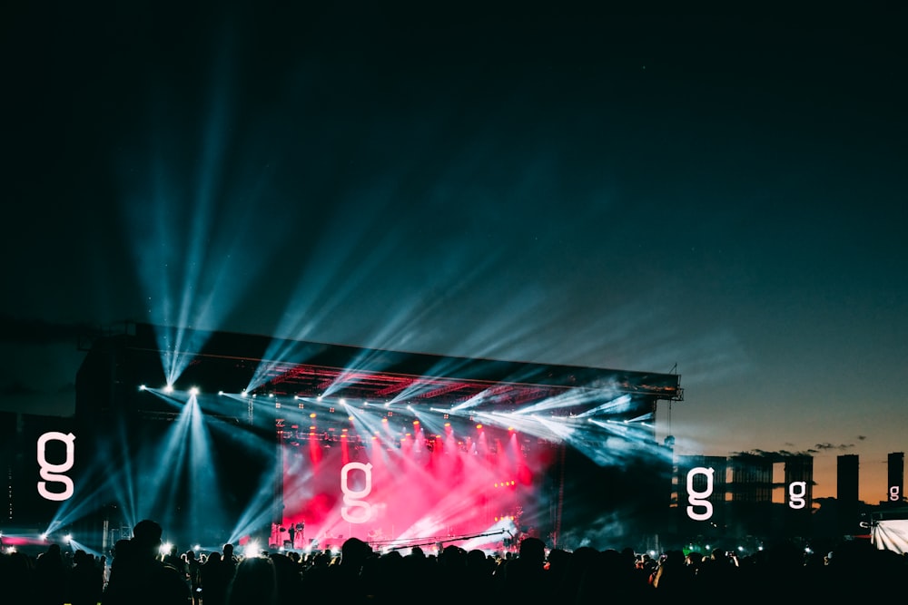 Silueta de personas y luces del escenario durante la noche