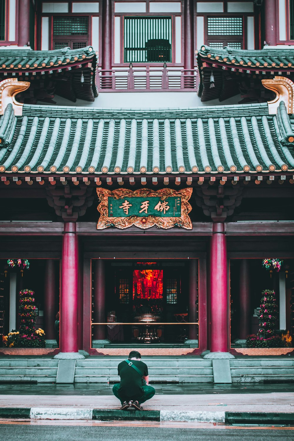 man squats in front of temple