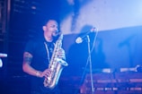 A saxophonist passionately playing on a dimly lit stage.