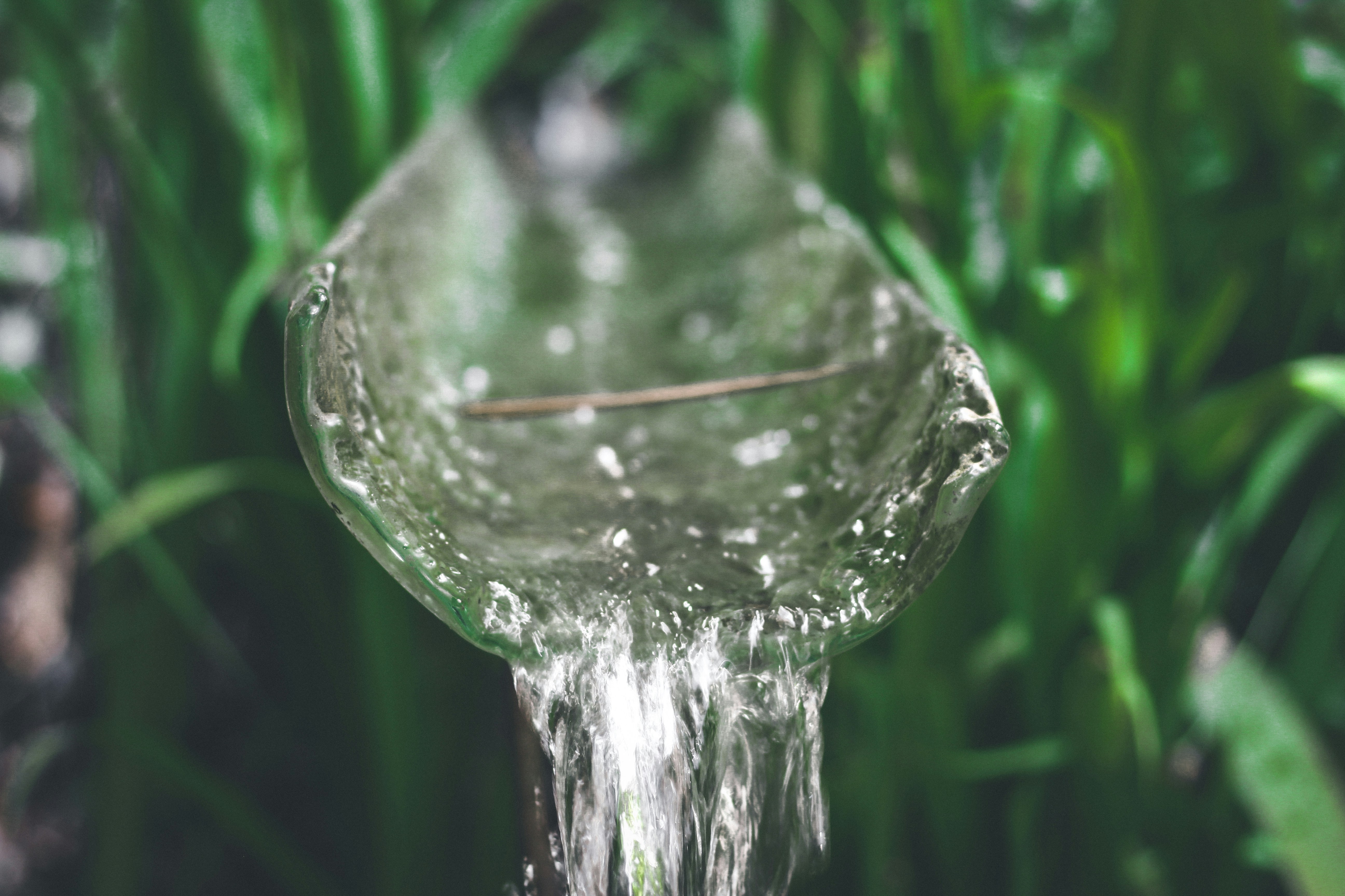 Pure drinking water flowing over glass surface with blue tones