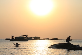A vibrant fishing boat setting out at dawn from the shores of Unawatuna, with golden light reflecting off the calm sea.
