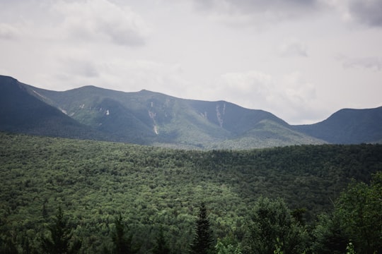 green and black mountains under white and gray sky at daytime in Kancamagus Pass United States