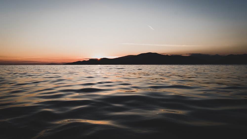 agua del océano y silueta de montañas fotografía de paisaje