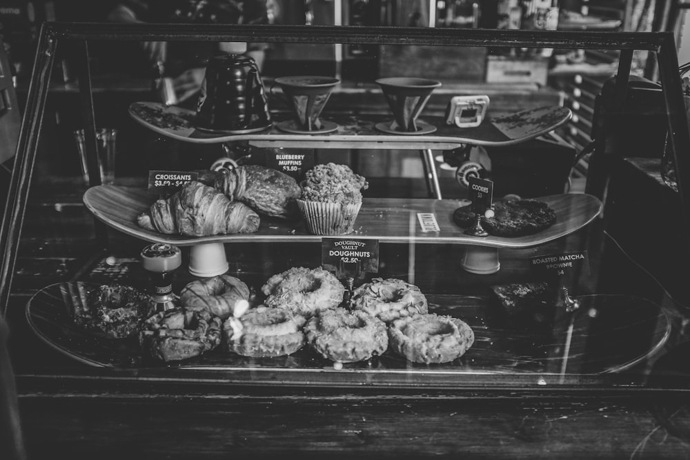 grayscale photo of breads on 3-tier rack