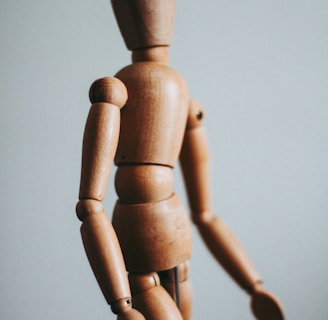 colse-up photo of brown wooden doll