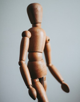 colse-up photo of brown wooden doll