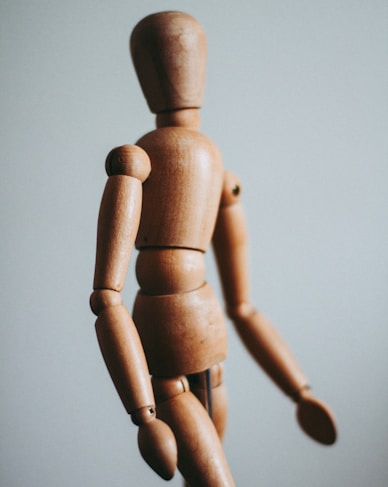 colse-up photo of brown wooden doll