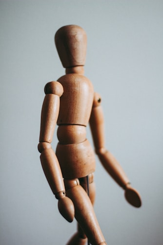 colse-up photo of brown wooden doll