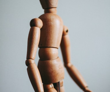 colse-up photo of brown wooden doll