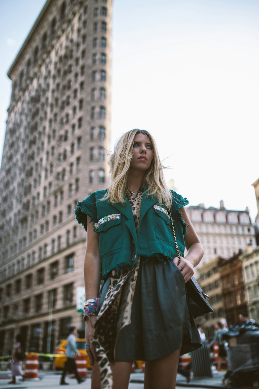 woman wearing green top standing near Flatiron building