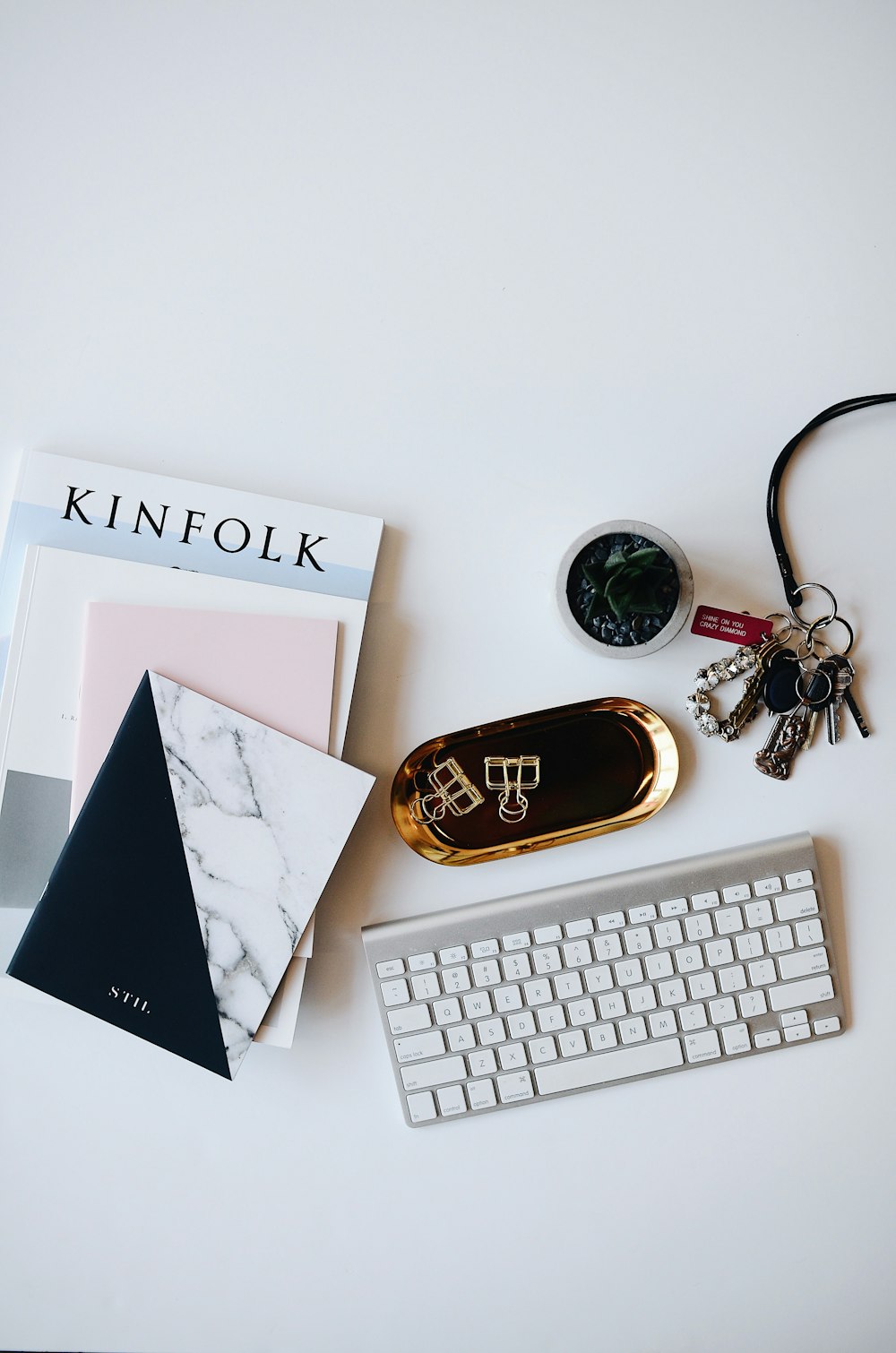 A flatlay image of a keyboard, books and other items.