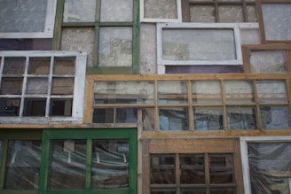 A variety of window frames and glass samples displayed in the workshop.