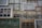A collection of variously sized and styled window frames arranged in a mosaic-like pattern. The frames vary in color from green to white and brown, displaying a mix of vintage and rustic designs. Some have panes of glass, while others appear more weathered.