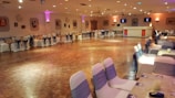 Banquet hall setup with round tables and soft lighting ready for an event.