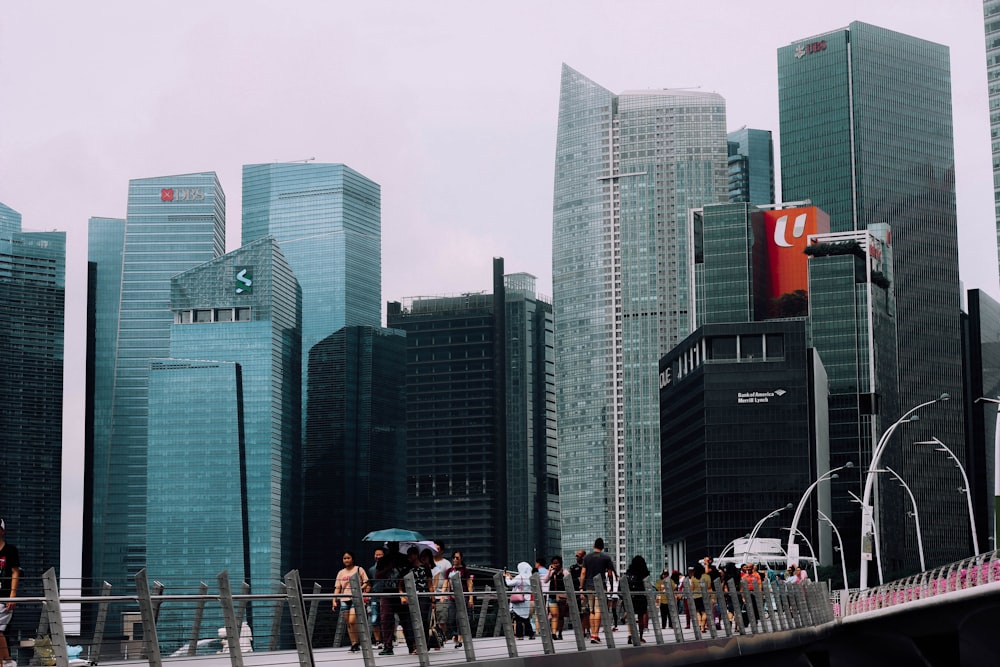 people walking on bridge surrounded with buildings