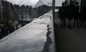Close-up of a professional cleaner carefully wiping a stainless steel handrail