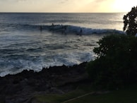 A stunning sunset view of surfers riding waves.