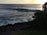 A group of surfers catching waves at sunset on a beautiful beach.