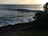 A group of surfers catching waves at sunset on a beautiful beach.