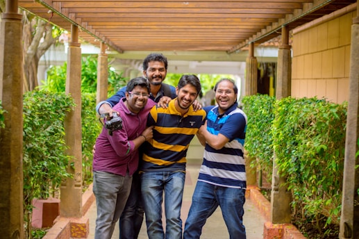 Four friends laughing together in a cozy treehouse, surrounded by books and sunlight.