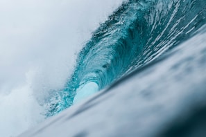 blue sea waves under white sky during daytime