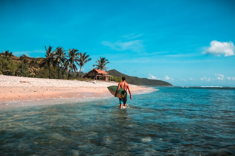 Wisatawan berselancar di pantai dekat kawasan sport tourism Mandalika Lombok