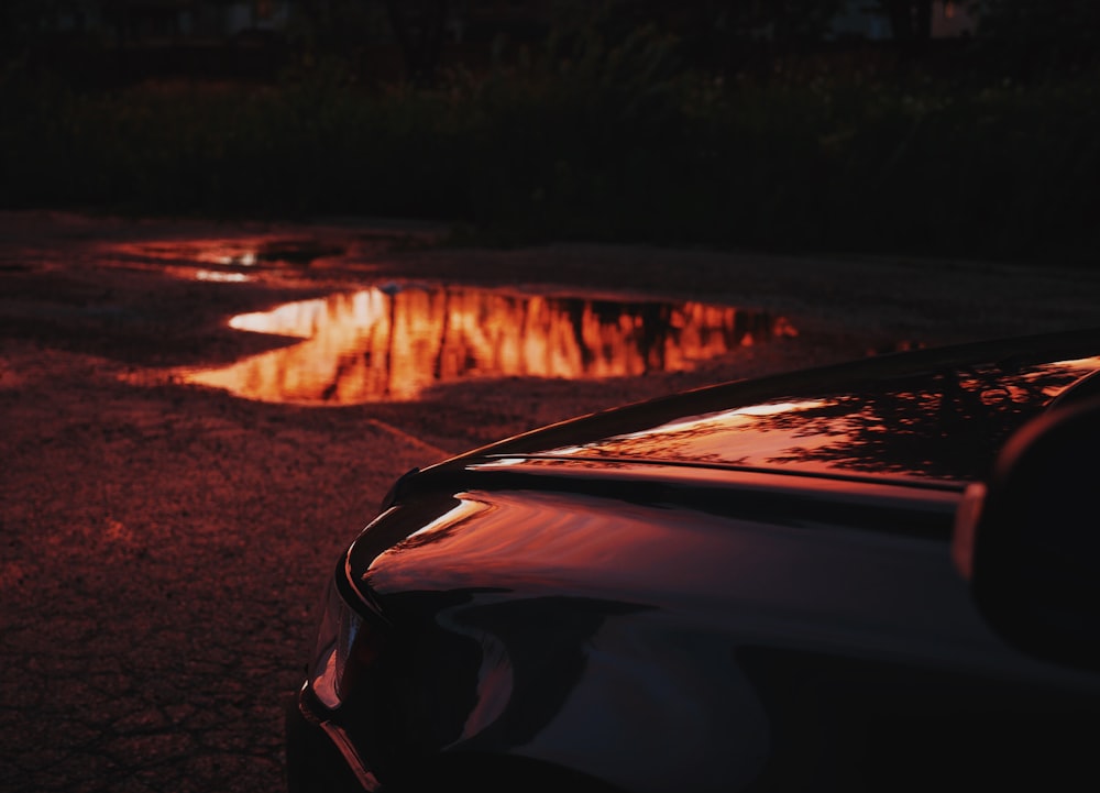 a reflection of a sunset in a puddle of water