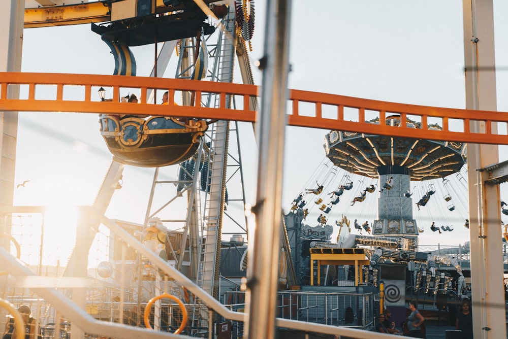 People at Morey's Piers & Beachfront Water Parks enjoying the swing ride and Ferris Wheel at sunset