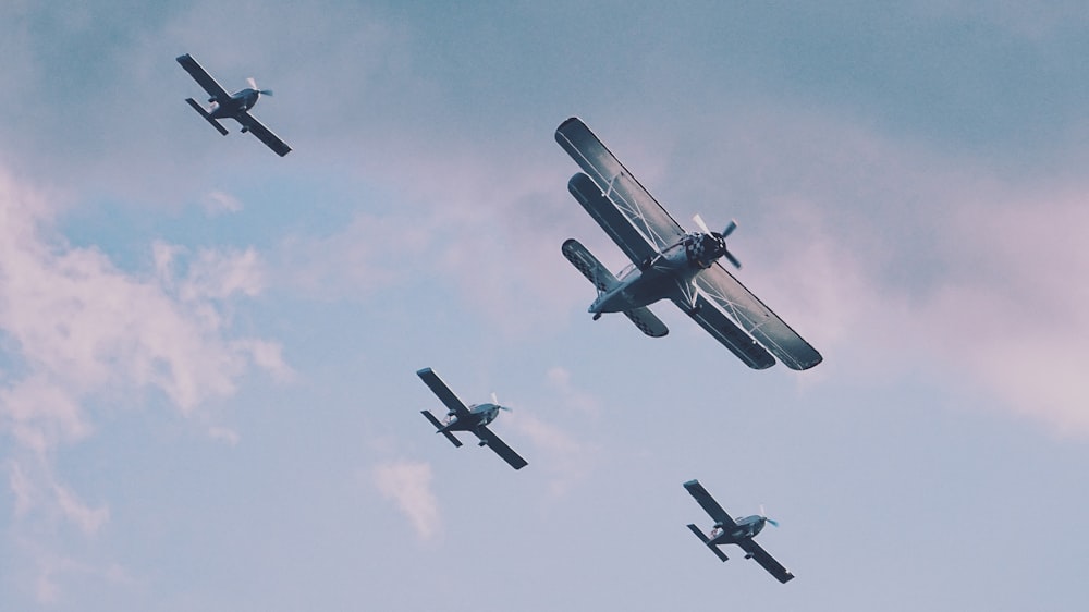 昼間、4機のプロペラ機が空中に浮かんでいる