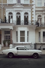 white coupe front of house