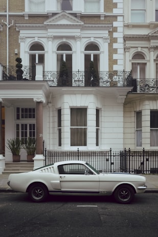 white coupe front of house