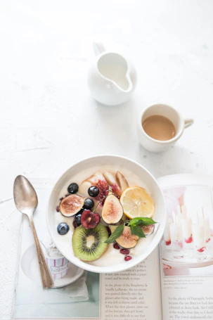 fruit yogurt bowl beside coffee cup