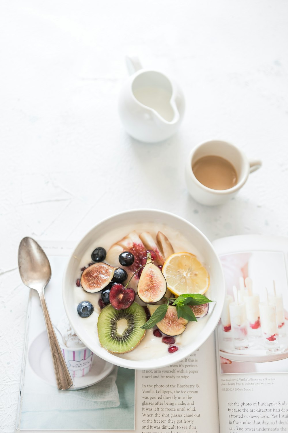 white ceramic plate beside gray steel spoon