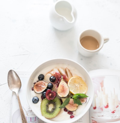 white ceramic plate beside gray steel spoon