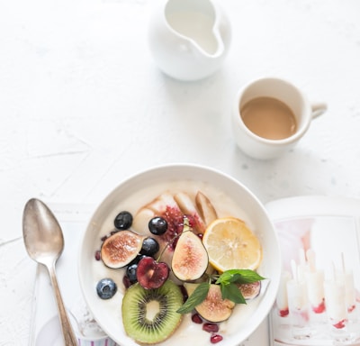 white ceramic plate beside gray steel spoon