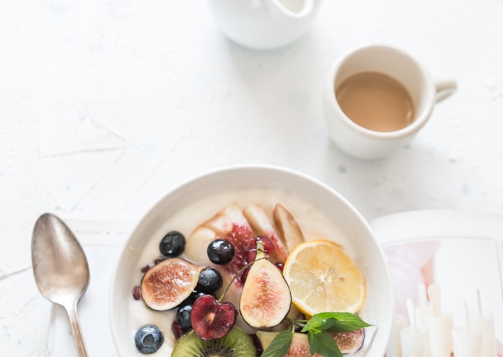 white ceramic plate beside gray steel spoon