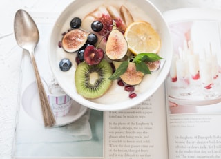 white ceramic plate beside gray steel spoon