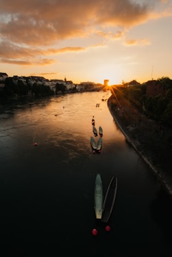 A serene view of the Ayeyarwaddy River at sunset with traditional boats floating gently.