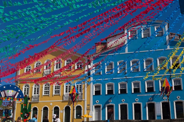 A colorful storefront of Mercantil Latina with vibrant ribbons and party decorations displayed outside.
