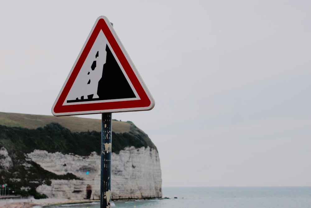 Signalisation noire et rouge près du plan d’eau pendant la journée