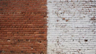 Bright, clean brickwork contrasted against a shaded, weathered section on a classic townhouse.