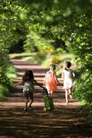 A playful shot of children running through a sunlit park in autumn.