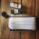 Close-up of a vintage film camera resting on a wooden table surrounded by notes.