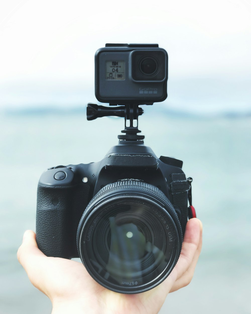 black DSLR camera with action camera