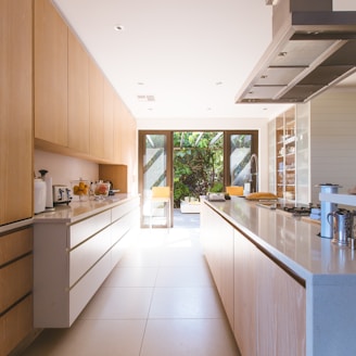 white wooden kitchen island and cupboard cabinets near glass panel door