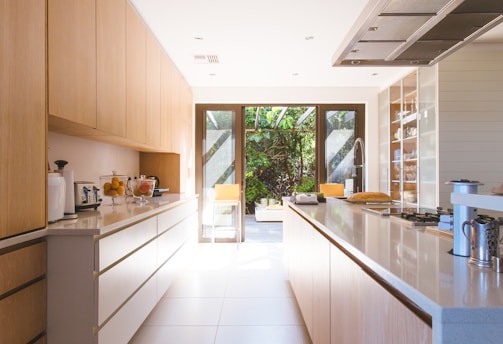 white wooden kitchen island and cupboard cabinets near glass panel door