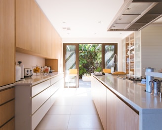 white wooden kitchen island and cupboard cabinets near glass panel door