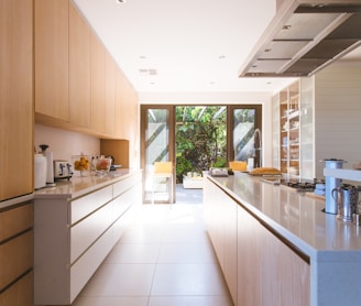 white wooden kitchen island and cupboard cabinets near glass panel door